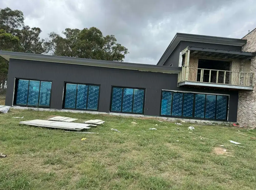 Charcoal-rendered modern home exterior with repainted window frames