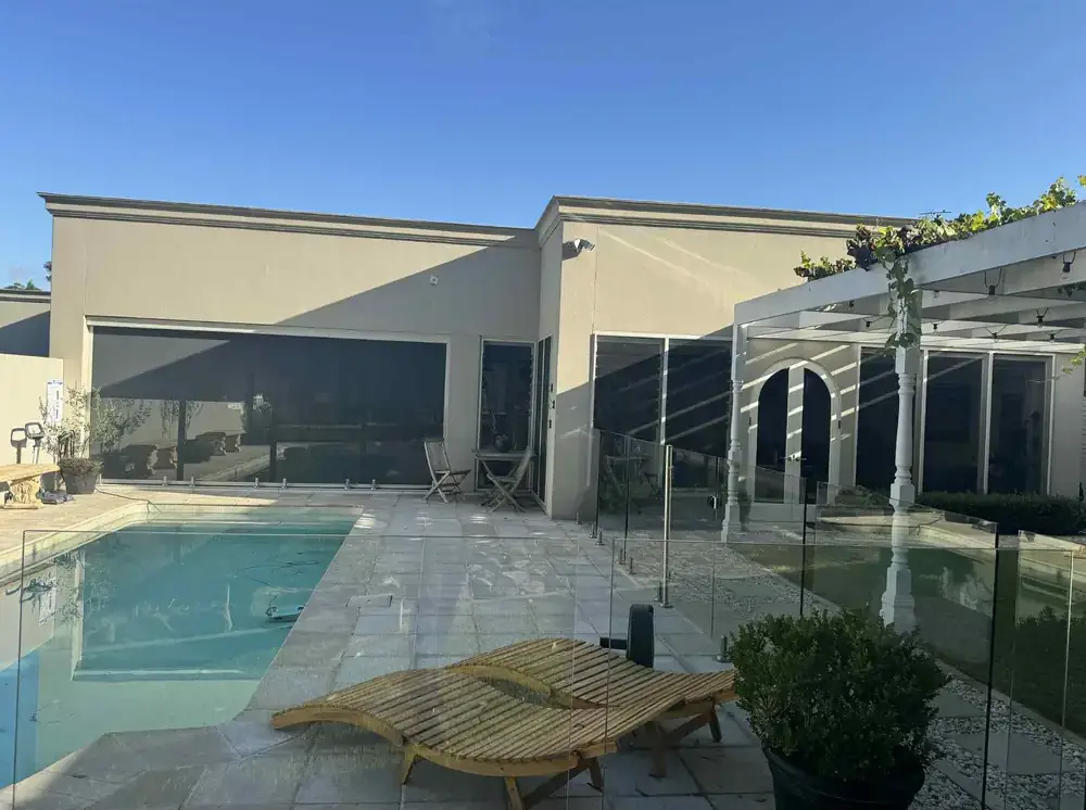Repainted rendered home and pergola beside a swimming pool